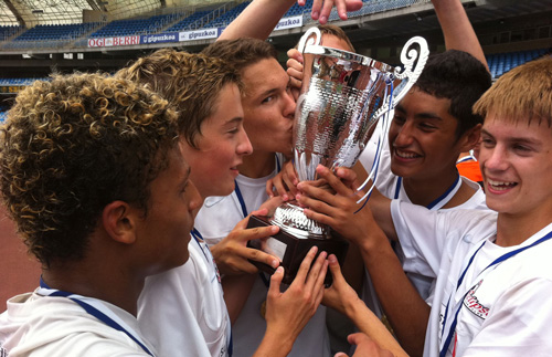 Soccer Winners holding and kissing silver trophey