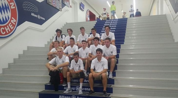 13 soccer players sitting on a marble stairway inside the Munich Allianz Arena