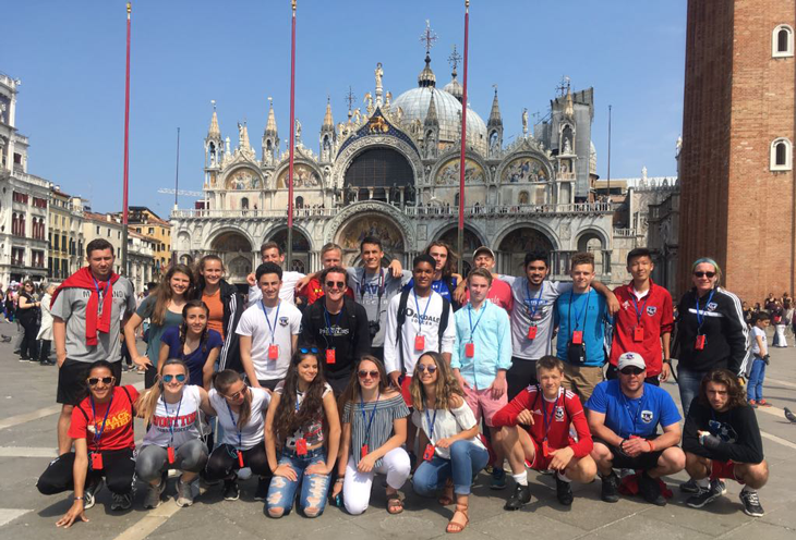 Group of Boys and Girls soccer players posing for a photo in front of the Marco Square Buildings in Venice.