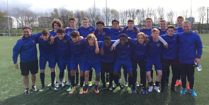 team of soccer players wearing blue tops and blue shorts