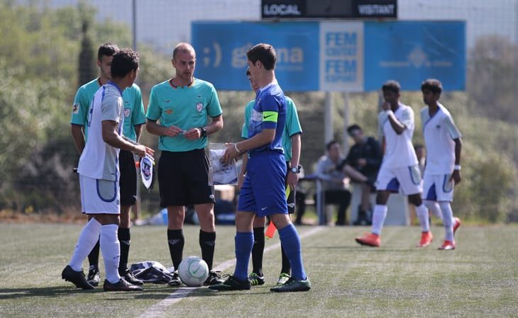 Team captains with three soccer referees meeting before a match.