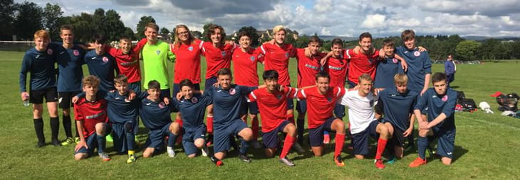 Two teams of players posing for the camera after a grueling soccer battle